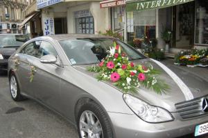 Fleurs sur le capot et les poignées d'une voiture pour un mariage